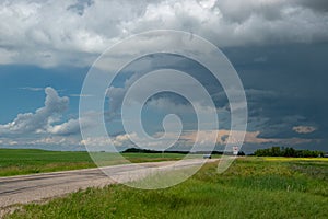 Truck approaching with looming storm clouds, Saskatchewan, Canad photo