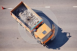 Truck body with crushed asphalt fragments during road repair, top view