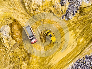 Truck and bulldozer on muddy terrain.