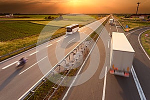 Truck bus and motorcycle on motorway at sunset