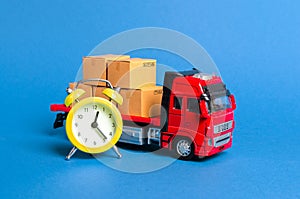 A truck with cargo cardboard boxes and a yellow alarm clock. Express delivery in short time concept. Temporary storage, limited