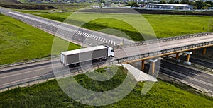 Truck with Cargo Semi Trailer Moving on Road in Direction. Highway intersection junction. Aerial Top View