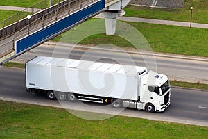 Truck cargo van on motorway under bridge in motion. Big commercial cargo van, freight car. Branding mockup