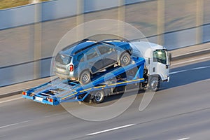 A truck carries an evacuated car on a highway, aerial view