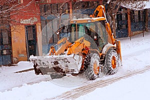 A truck ceaning the street while snowing