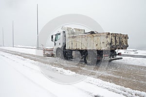 Truck cleaning winter road covered with snow