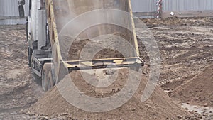 Truck at a construction site pours sand from a body for construction, industry, background