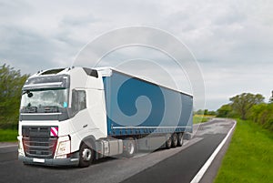 Truck with container on highway, cargo transportation concept. Logistics and warehouse transportation