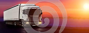 Truck with container on highway, cargo transportation concept. Sunset background with copy space. Panoramic view
