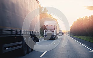 Truck with container on highway with sun light, concept cargo transportation. Blur move effect