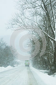 Truck on a country road in the snowfall.