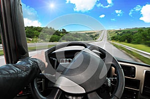 Truck dashboard with driver`s hand on the steering wheel on the