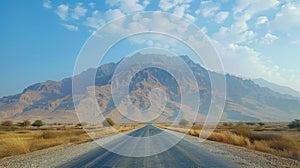 Truck on desert road with distant mountains under cloudy sky