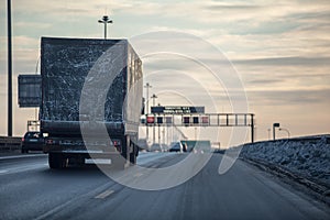 Truck on dirty winter ring road in the evening