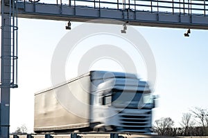 Truck drive through the highway through the toll gate, toll charges, blurred motion in the image