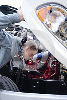 Truck driver check semi truck engine looking inside hood