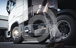 Truck Driver is Checking the Truck`s Safety Maintenance Checklist. Lorry Fixing. Truck Inspection Safety of Semi Truck Wheels Tire