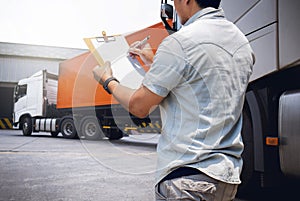 Truck Driver is Checking the Truck`s Safety Maintenance Checklist. Lorry. Inspection Semi Truck Wheels and Tires. Shipping Trucks