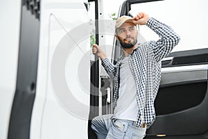 Truck driver climbing into cab of semi-truck