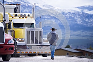 Truck driver going to customized impressive yellow semi truck photo