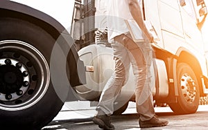 Truck driver holding clipboard walking with inspecting safety vehicle maintenance checklist semi truck.