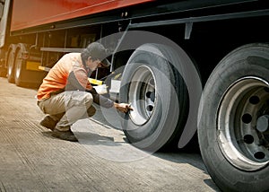 Truck driver inspecting safety daily check a truck wheels