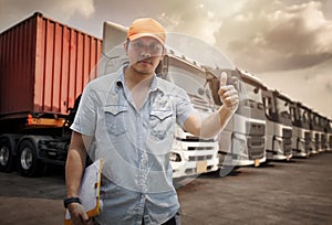 Truck Driver is Looking and Giving Thumb-Up. Checking the Truck`s Safety of semi Truck. Mechanic Repairman Auto Service Shop.