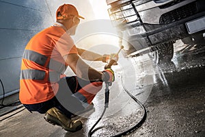 Truck Driver Pressure Washing a Vehicle