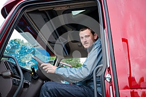 Truck driver in semi truck cab with modern dashboard