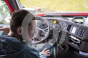 Truck driver in semi truck cab with modern dashboard photo