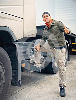 Truck driver with semi truck giving thumbs-up