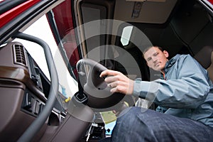 Truck driver sitting in cab of modern semi truck