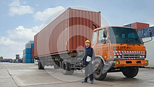 Truck driver standing by container truck at containers yard and cargo