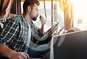 Truck driver talking by CB radio system in his vehicle