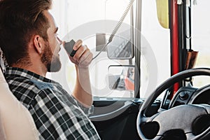 Truck driver talking by CB radio system in his vehicle