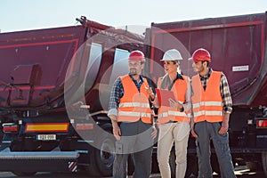 Truck drivers and dispatcher in front of lorries in freight forwarding company photo