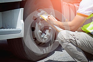 Truck Drivers Holding A Clipboard Checking Truck Wheels Tires. Maintenance Checklist. Truck Inspection Freight Truck Transport.