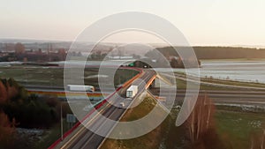 A truck drives over a bridge crossing a high-speed highway with heavy traffic