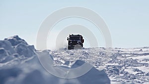 The truck drives on a snowy off-road in the arctic