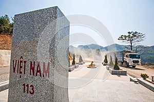 Truck driving on the dirt road crossing a border sign of Vietnam, Vietnam-Laos border. Tay Trang, Dien Bien Phu, Vietnam