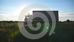 Truck driving on a highway with sun flare at background. Lorry rides through the countryside with beautiful landscape