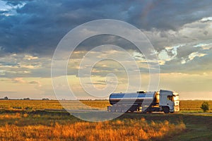 Truck driving on a road at sunset. Beautiful sunset cloudy sky