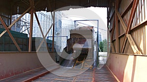 Truck with empty trail in a grain factory warehouse.