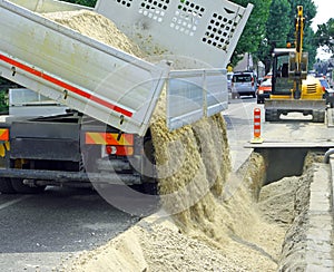 Truck in the excavation after laying of underground electric cab