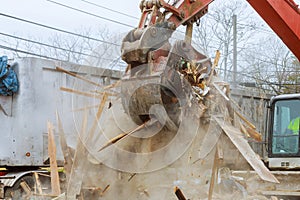 Truck with excavator loads construction waste on a dump truck