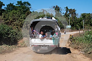 A truck filled with local people on a dirt road close to Chaung Thar, Irrawaddy, Myanmar