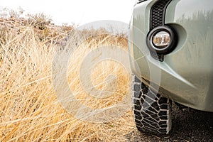 Truck Front Wheel Low Angle Next to Dry Grass