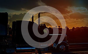 Truck highway road with transporting on the asphalt expressway against sky during sunset