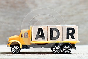 Truck hold block in word ADR Abbreviation of Adverse drug reaction on wood background