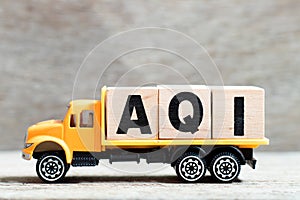 Truck hold block in word AQI Air quality index on wood background